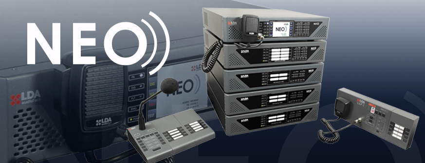 NEO 8060 Sprachalarmzentralen im 19-Zoll-Rack, davor Notfall-Sprechstellen mit Mikrofon